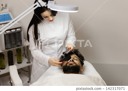 Dermatologist performing skin examination on male patient Dermatologist performing skin examination on male patient 142317071