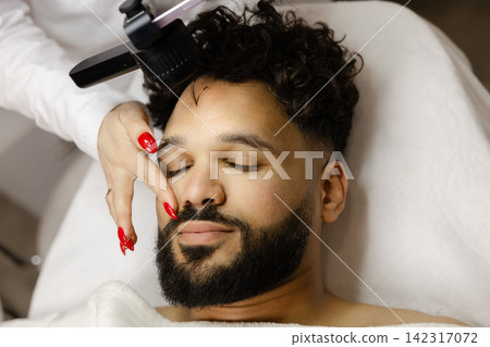 Man receiving skin examination with dermoscope for mole check Man receiving skin examination with dermoscope for mole check 142317072