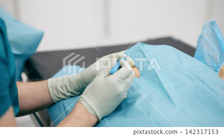 Surgeon performing medical procedure with scalpel on patient 142317153