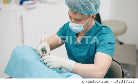 Doctor performing medical procedure in hospital operating room Doctor performing medical procedure in hospital operating room 142317158