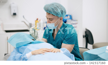 Surgeon performing eye surgery on patient in operating room Surgeon performing eye surgery on patient in operating room 142317160