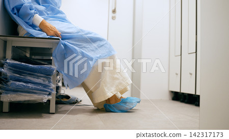 Person preparing for surgery in hospital locker room Person preparing for surgery in hospital locker room 142317173