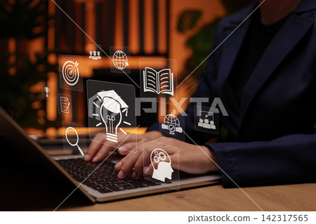 E-learning and online education concept. Person using laptop with icons of books, graduation, and digital learning tools, symbolizing knowledge sharing, virtual classrooms, and skill development. E-learning and online education concept. Person using laptop with icons of books, graduation, and digital learning tools, symbolizing knowledge sharing, virtual classrooms, and skill development. 142317565