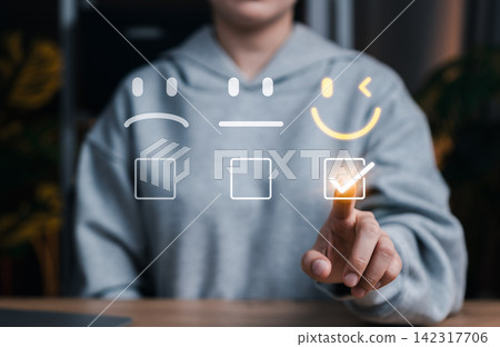 Customer satisfaction and feedback rating concept with user selecting happy face icon on digital interface, representing user experience, service quality, review system, and emotional engagement. Customer satisfaction and feedback rating concept with user selecting happy face icon on digital interface, representing user experience, service quality, review system, and emotional engagement. 142317706
