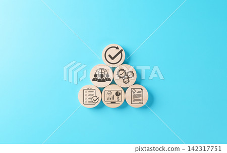 Quality assurance and certification compliance concept. Wood block showing icon of process control, teamwork, analytics, audit, certified document and approval on blue background for business strategy Quality assurance and certification compliance concept. Wood block showing icon of process control, teamwork, analytics, audit, certified document and approval on blue background for business strategy 142317751