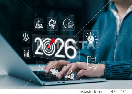 Business Goals and Growth Strategy for 2026 Concept. Businessperson working on a laptop with the year 2026, target icons, and business growth symbols, challenges strategic planning and future success. Business Goals and Growth Strategy for 2026 Concept. Businessperson working on a laptop with the year 2026, target icons, and business growth symbols, challenges strategic planning and future success. 142317843