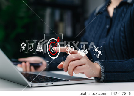 Business Goal Achievement and Strategic Performance Concept. Businesswoman using laptop with icons for target achievement, analytics, teamwork, process optimization, partnership, innovation planning Business Goal Achievement and Strategic Performance Concept. Businesswoman using laptop with icons for target achievement, analytics, teamwork, process optimization, partnership, innovation planning 142317866