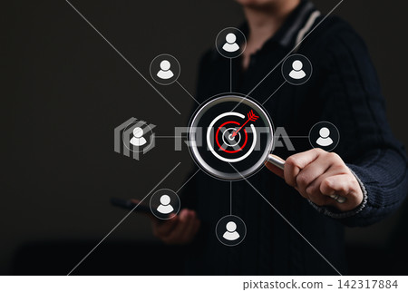 Audience Targeting and Customer Segmentation Concept. Person holding magnifying glass over target with user icon representing customer analysis, market segmentation, lead targeting, audience selection Audience Targeting and Customer Segmentation Concept. Person holding magnifying glass over target with user icon representing customer analysis, market segmentation, lead targeting, audience selection 142317884