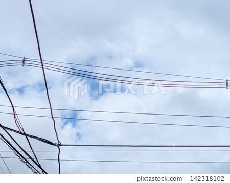Multiple power lines crossing a cloudy sky / Sky background material representing the daily life and infrastructure of a city Multiple power lines crossing a cloudy sky / Sky background material representing the daily life and infrastructure of a city 142318102