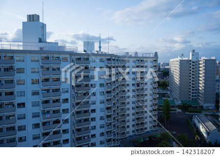 東京都住宅供應公司的大型南砂住宅區,沐浴在暮色的藍色燈光中,整齊排列的住宅大樓群清晰可見。 東京都住宅供應公司的大型南砂住宅區,沐浴在暮色的藍色燈光中,整齊排列的住宅大樓群清晰可見。 142318207