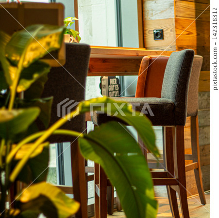 Cozy Cafe Interior with Wooden Furniture and Plants Cozy Cafe Interior with Wooden Furniture and Plants 142318312