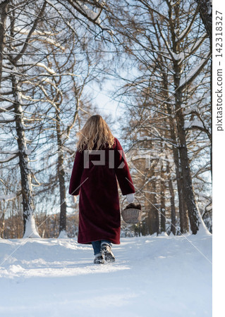 Woman walking alone through snowy winter forest Woman walking alone through snowy winter forest 142318327