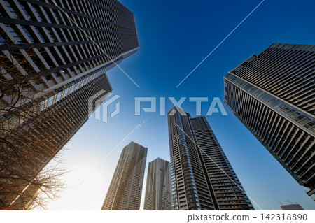 一棟超高層公寓大樓在藍天的襯托下格外醒目,沐浴在耀眼的陽光中。 一棟超高層公寓大樓在藍天的襯托下格外醒目,沐浴在耀眼的陽光中。 142318890