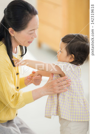 一位母親和祖母抱著一個一歲的女嬰。 一位母親和祖母抱著一個一歲的女嬰。 142319618