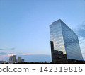 暮色籠罩下的天空和一座現代化的玻璃帷幕牆高層辦公大樓（留白） 142319816