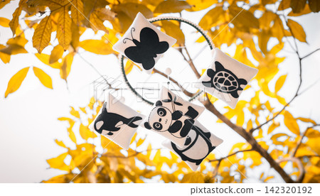 Cot mobile with cute felt animal decorations, a panda, penguin, turtle, whale, and butterfly, arranged around a circular frame hang in a tree branch Cot mobile with cute felt animal decorations, a panda, penguin, turtle, whale, and butterfly, arranged around a circular frame hang in a tree branch 142320192