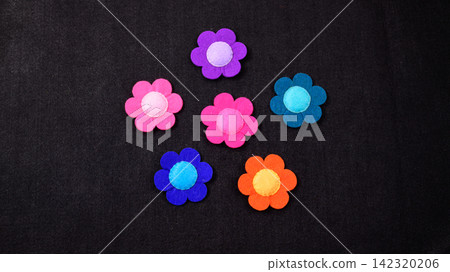 Colorful felt flower shapes on a black background with copy space Colorful felt flower shapes on a black background with copy space 142320206