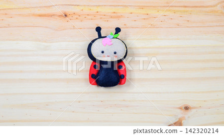 Cute handmade ladybug on a wooden background with copy space Cute handmade ladybug on a wooden background with copy space 142320214