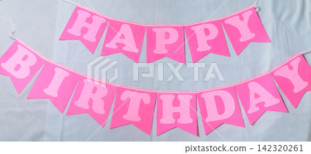 Pink happy birthday pennant banner arranged as a festive party decoration on a light background 142320261
