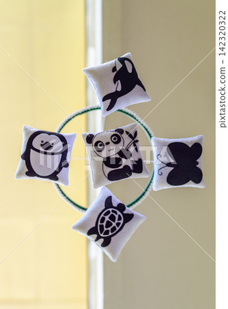 Cot mobile with cute felt animal decorations, a panda, penguin, turtle, whale, and butterfly, arranged around a circular frame view from below Cot mobile with cute felt animal decorations, a panda, penguin, turtle, whale, and butterfly, arranged around a circular frame view from below 142320322