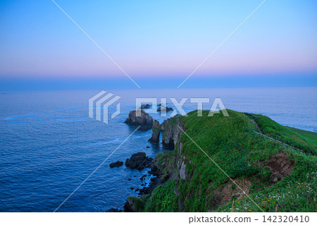 北海道東部的桐多普岬陡峭的懸崖，沐浴在柔和的晚霞和寧靜的大海中。 142320410