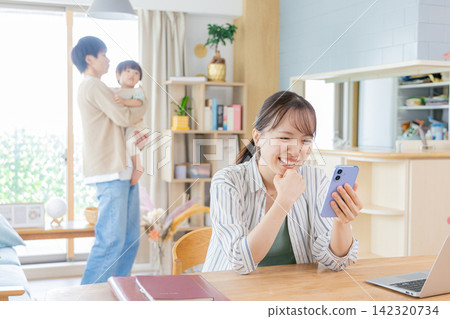 一位母親正在用智慧型手機搜尋育兒資訊。 一位母親正在用智慧型手機搜尋育兒資訊。 142320734