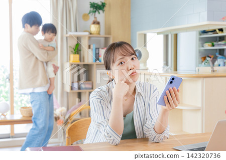 一邊照顧孩子一邊看智慧型手機的母親們 一邊照顧孩子一邊看智慧型手機的母親們 142320736