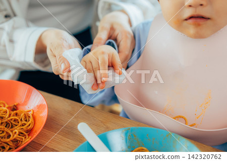 媽媽在用餐時擦拭孩子的手 142320762