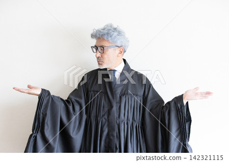 一位身穿法袍的男法官張開雙臂,表示公正無私的判決。 一位身穿法袍的男法官張開雙臂,表示公正無私的判決。 142321115