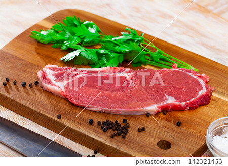 Sliced pieces of raw beef tenderloin on wooden cutting board Sliced pieces of raw beef tenderloin on wooden cutting board 142321453