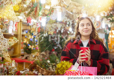 Happy girl with paper cup of coffee walking in Christmas fair Happy girl with paper cup of coffee walking in Christmas fair 142321464