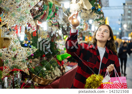 Portrait of woman customer near counter with Christmas gifts in evening time Portrait of woman customer near counter with Christmas gifts in evening time 142321508