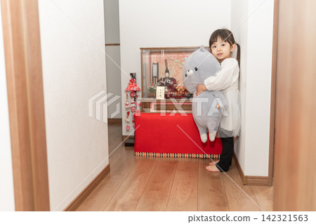 一位3歲女孩在家中享受女兒節(Hina Matsuri)。 一位3歲女孩在家中享受女兒節(Hina Matsuri)。 142321563