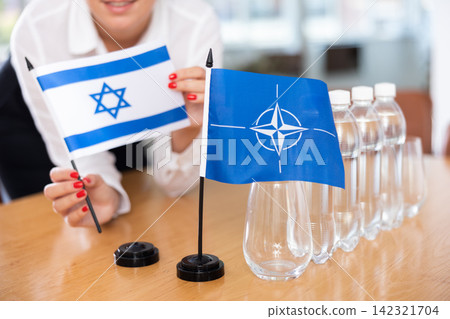 Flags of Israel and Greece stand on negotiating table in office Flags of Israel and Greece stand on negotiating table in office 142321704