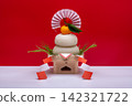 A photograph featuring a real "kagami mochi" (a traditional New Year's rice cake) in the center, against a red and white background, with a low sanbo (a type of offering stand). 142321722