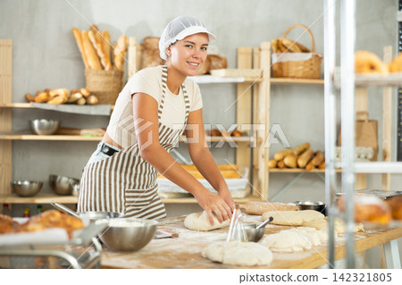 Young woman works in bakery as baker, kneads and prepare dough, works with flour. Young woman works in bakery as baker, kneads and prepare dough, works with flour. 142321805