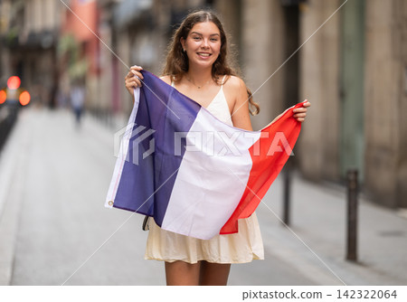 Woman waving France flag on street of summer European city 142322064