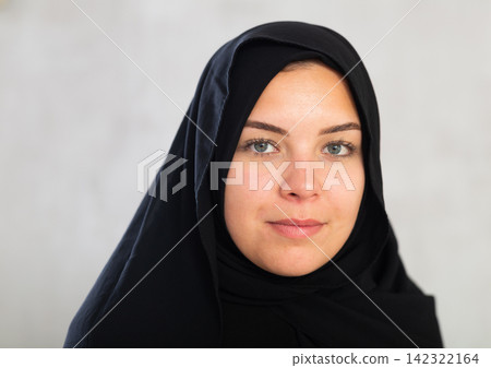 Cheerful young muslim lady in black traditional hijab 142322164