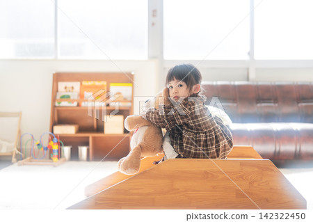 一個女孩在教室裡玩毛絨玩具。 一個女孩在教室裡玩毛絨玩具。 142322450