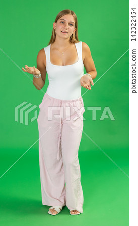 Teenage girl explaining or telling something in front of green screen 142322454