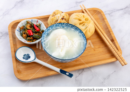egg drop soup with poached egg steamed baozi and pickled vegetables 142322525