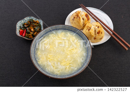 egg drop soup with poached egg steamed baozi and pickled vegetables 142322527