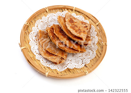 crispy rolled Indian whole wheat flatbread paratha served on a basket crispy rolled Indian whole wheat flatbread paratha served on a basket 142322555