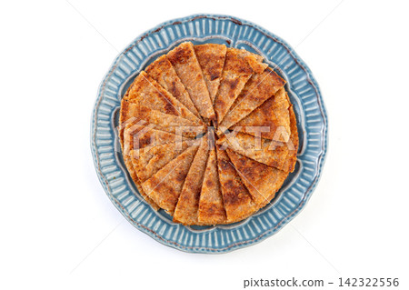 crispy rolled Indian whole wheat flatbread paratha served on a basket crispy rolled Indian whole wheat flatbread paratha served on a basket 142322556