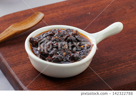spicy fermented black soybeans condiment with chili oil on golden spoon spicy fermented black soybeans condiment with chili oil on golden spoon 142322788