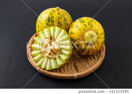whole and Cut Striped Oriental Melon whole and Cut Striped Oriental Melon 142323595