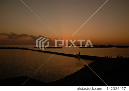 黃昏時分,堤岸的輪廓和水面的景象。 黃昏時分,堤岸的輪廓和水面的景象。 142324457