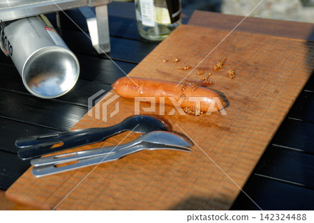 Sausages and cooking utensils on a wooden cutting board Sausages and cooking utensils on a wooden cutting board 142324488