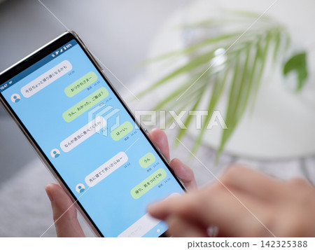 一張照片顯示，一名女子正在使用智慧型手機上的即時通訊應用程式與她的配偶、男友或家人進行日常溝通（螢幕截圖僅供參考）。 142325388