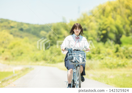 School girls riding a bicycle School girls riding a bicycle 142325924